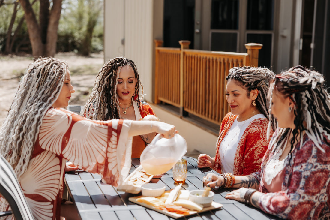 Womena wearing dreadlock extensions enjoying lunch outside together