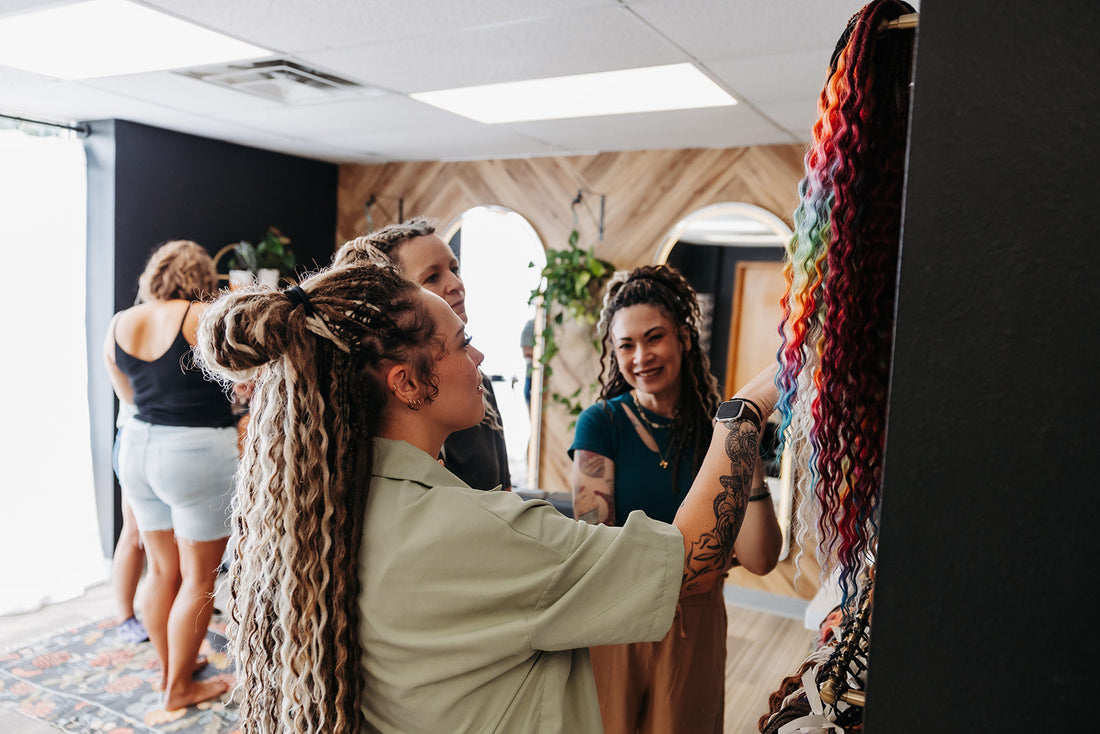 Women looking at dreadlock extensions inside of a salon