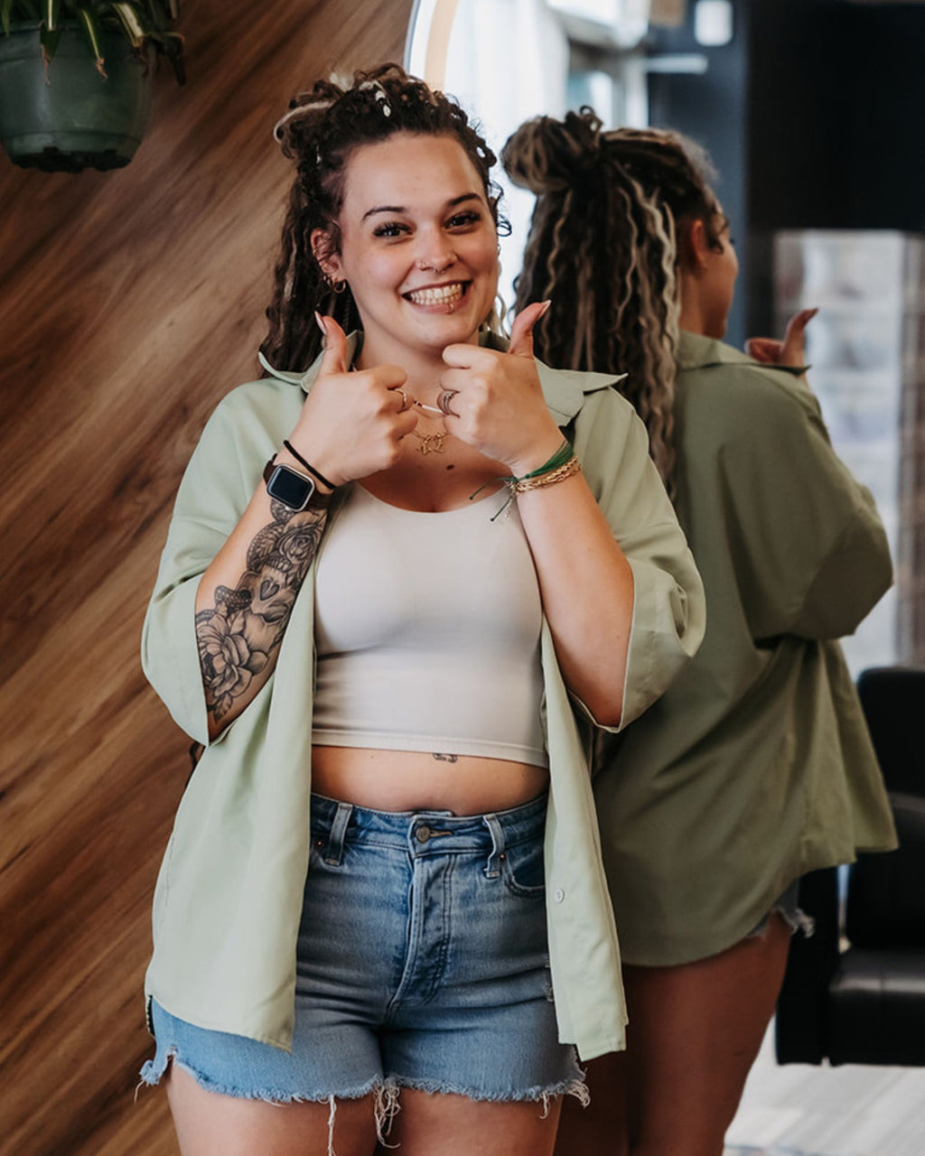 Woman wearing Venus Long Braid-in Hair Extensions giving a thumbs-up gesture indoors