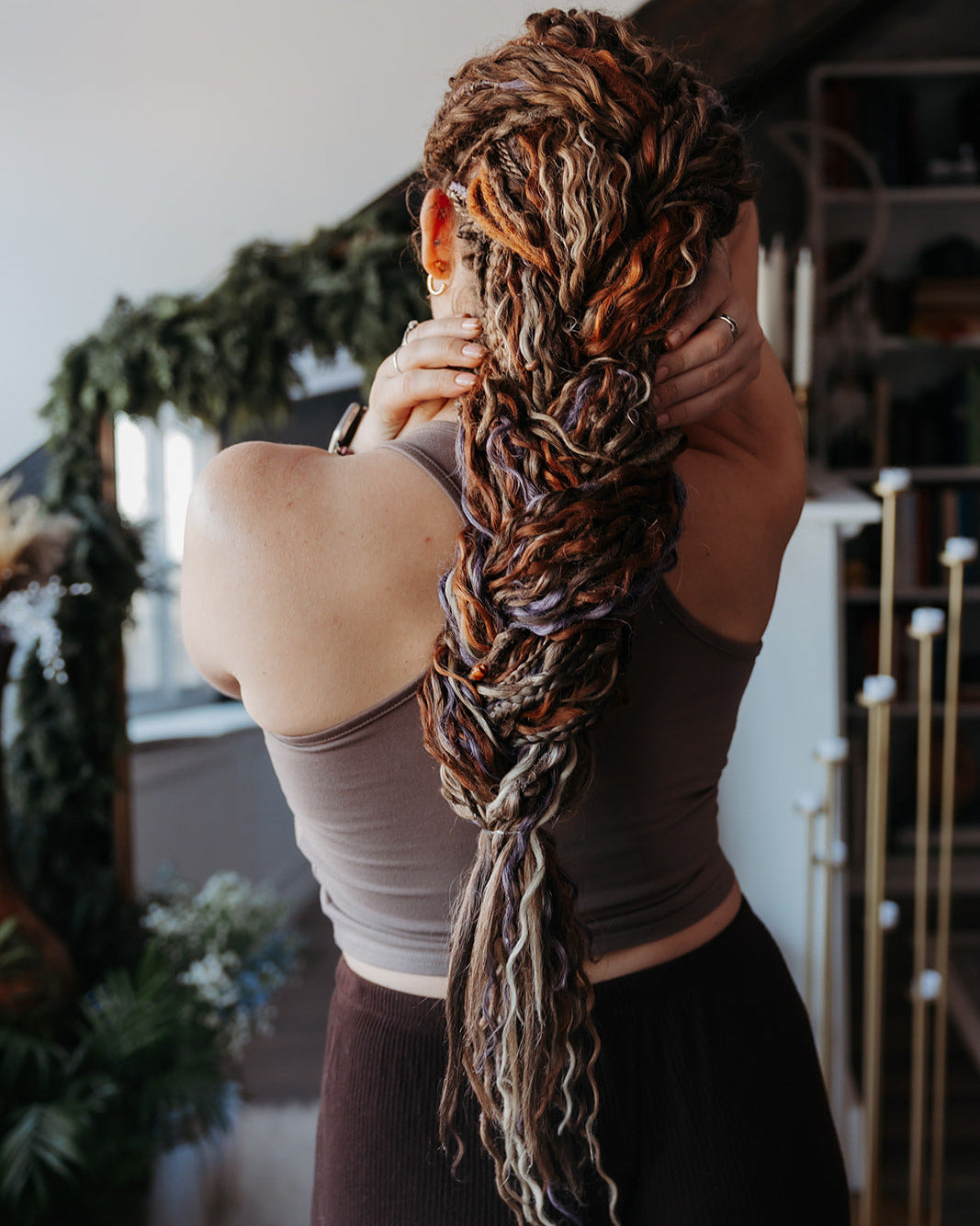 Person with Venus Long Braid-in Hair Extensions in a room with plants and decor