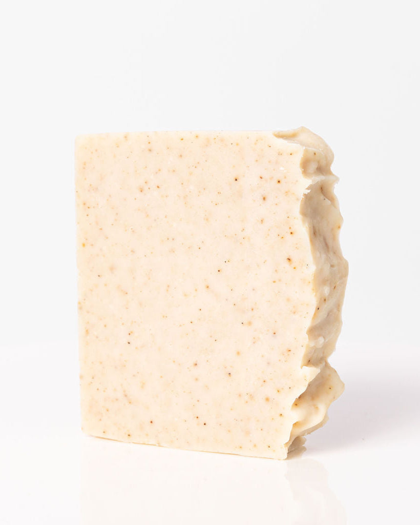 A solid shampoo bar with a light beige color, slightly textured surface, displayed on a white background.