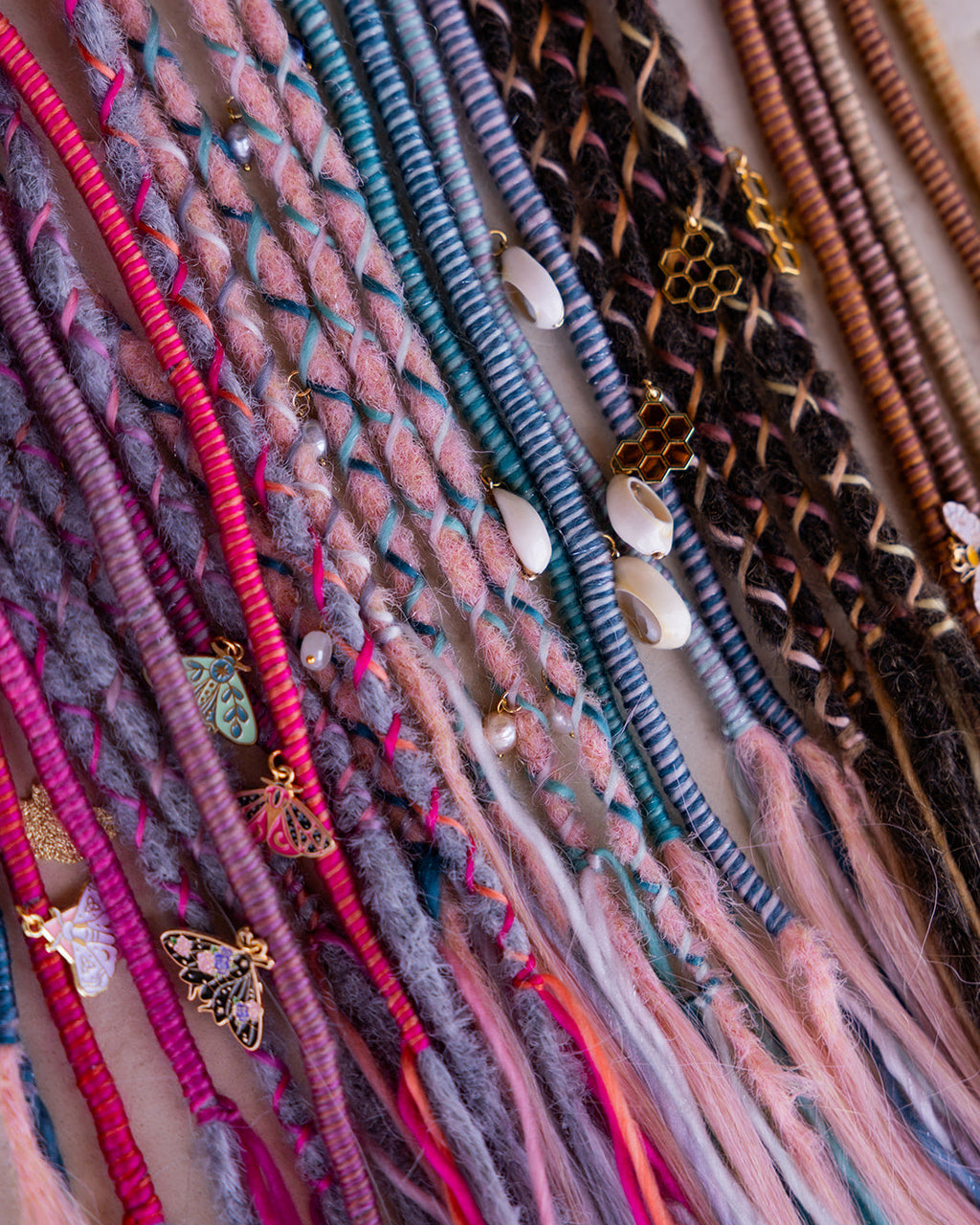 Close up of multiple accent straight wraps with multi colored wrap fibers, and charm accents