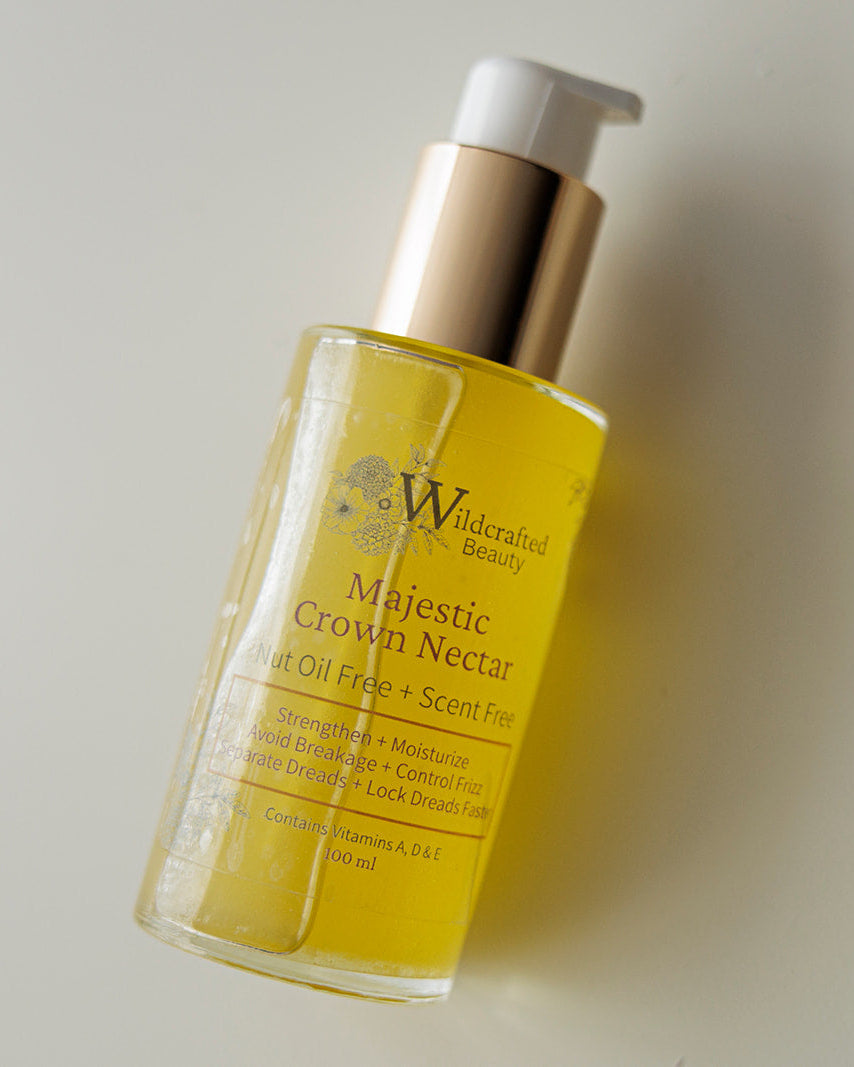 Clear glass bottle of Wildcrafted Beauty's Majestic Crown Nectar on a soft white background.