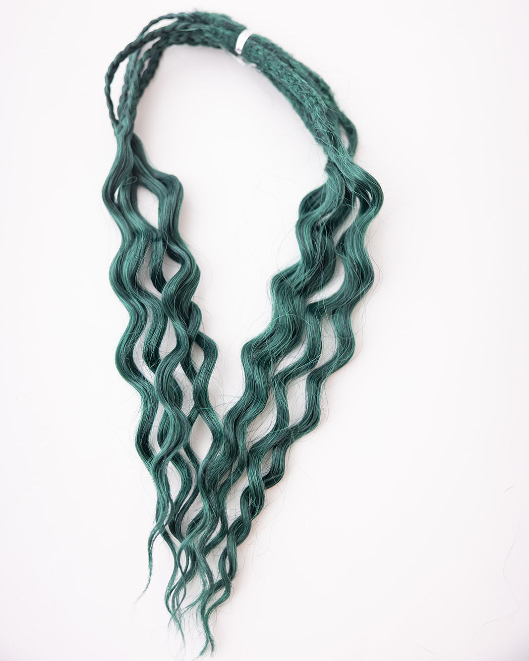 A bundle of short, wavy synthetic extensions in a deep green color, tied together with a white elastic band and displayed against a plain white background.