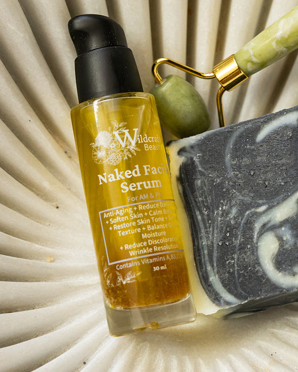 Facial serum and cleansing bar on stone decorative bowl with facial roller.