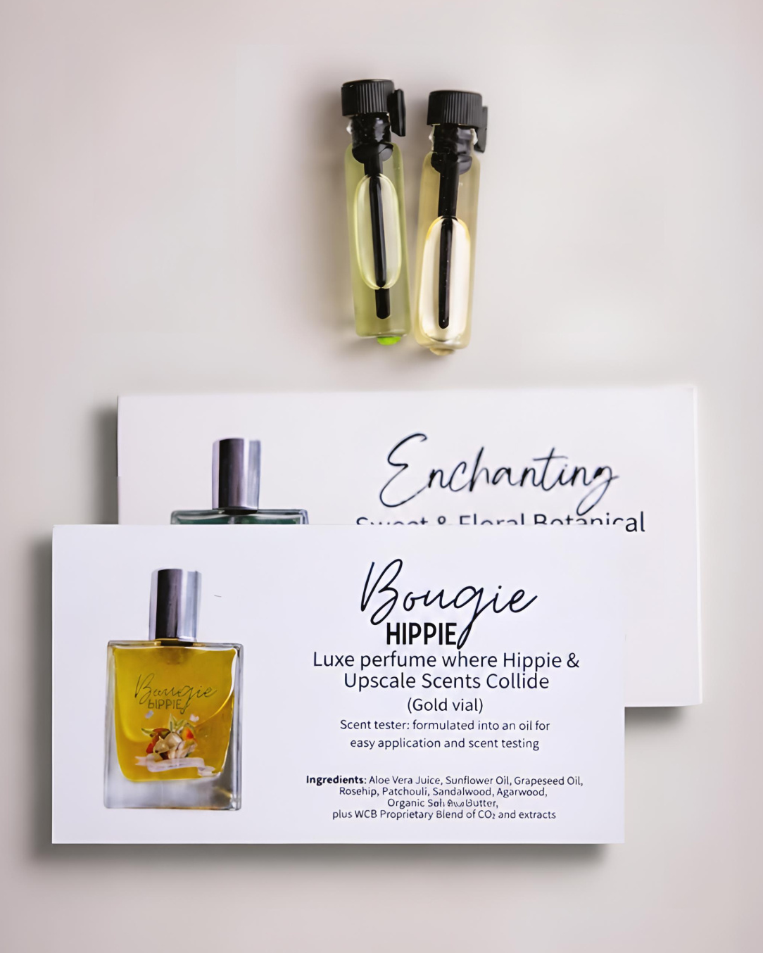 2 vials of oil, one green one gold, with 2 cards stacked underneath.  One says Enchanting, the other says Bougie Hippie.  