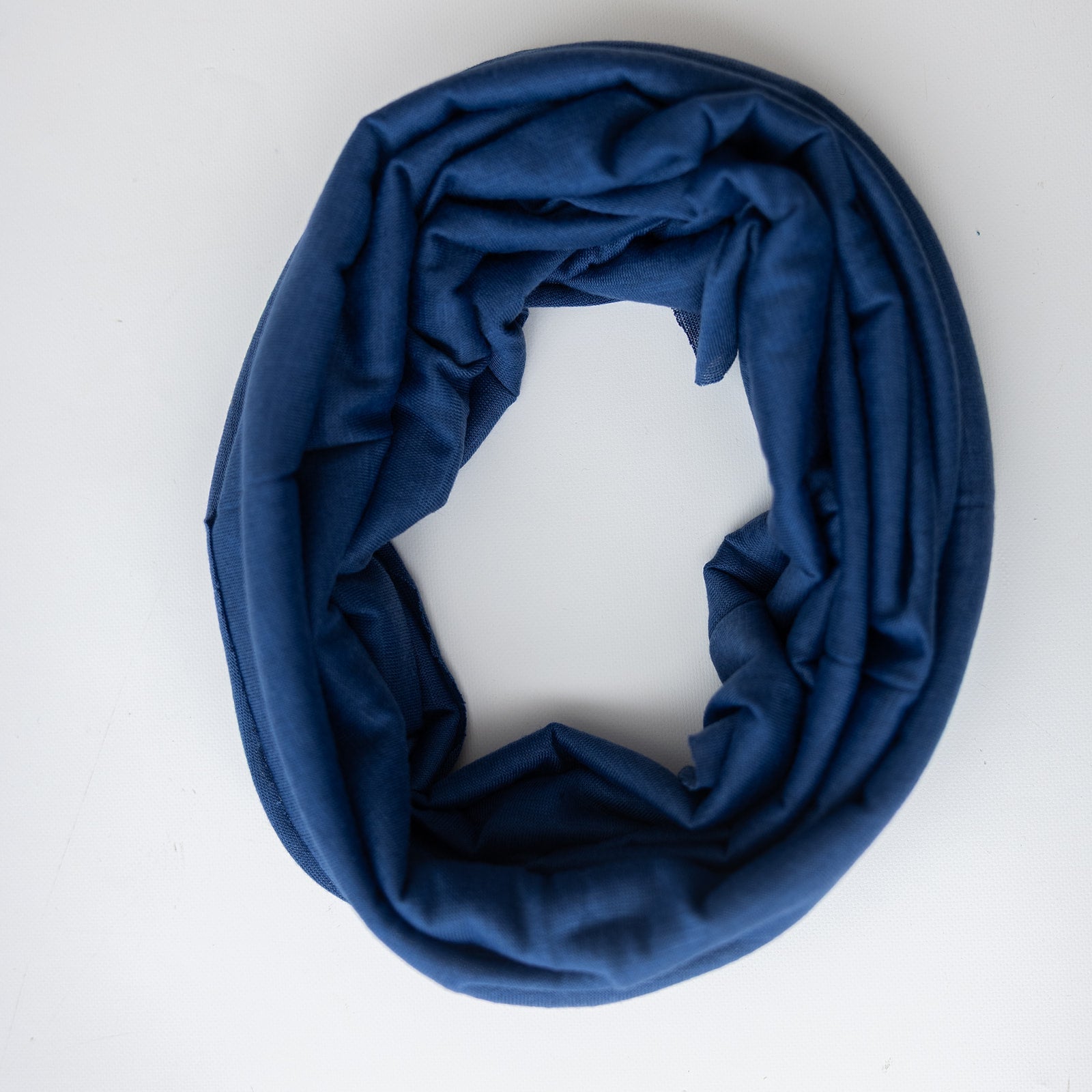 A blue headband styled in a loose loop on a plain white background.