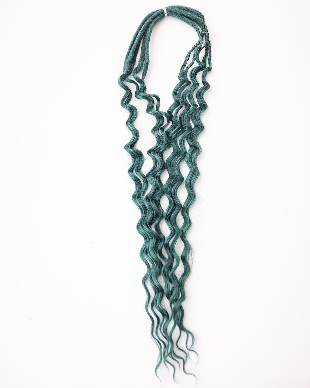 A bundle of long, wavy synthetic hair extensions in a deep green color, laid flat on a clean white background.