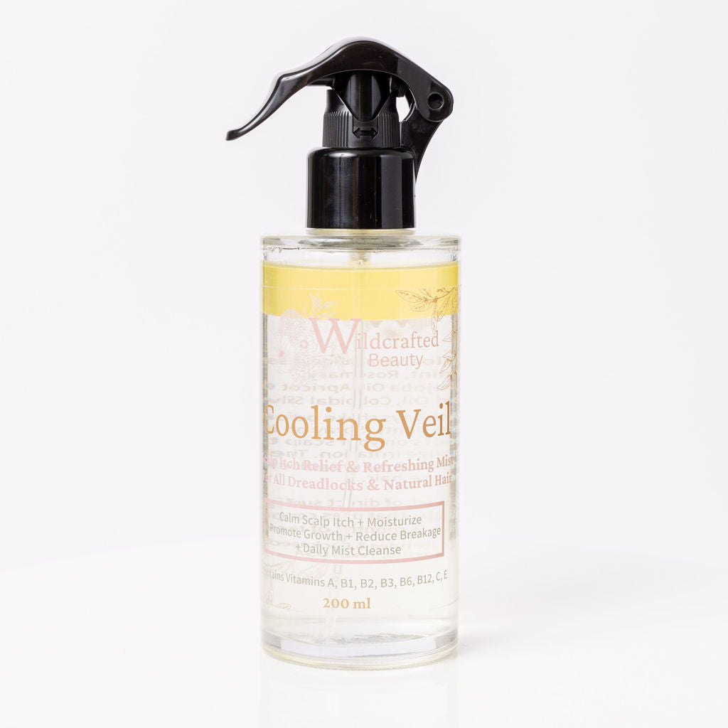 A clear spray bottle labeled 'Cooling Veil' with a yellow liquid visible through the bottle, indicating it is a scalp soothing mist.