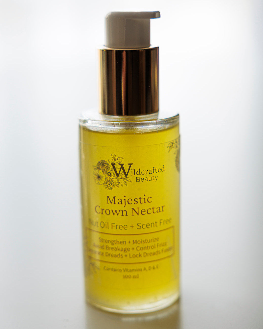 A 100ml bottle of Majestic Crown Nectar hair serum with a pump dispenser, labeled as scent-free and nut oil-free.