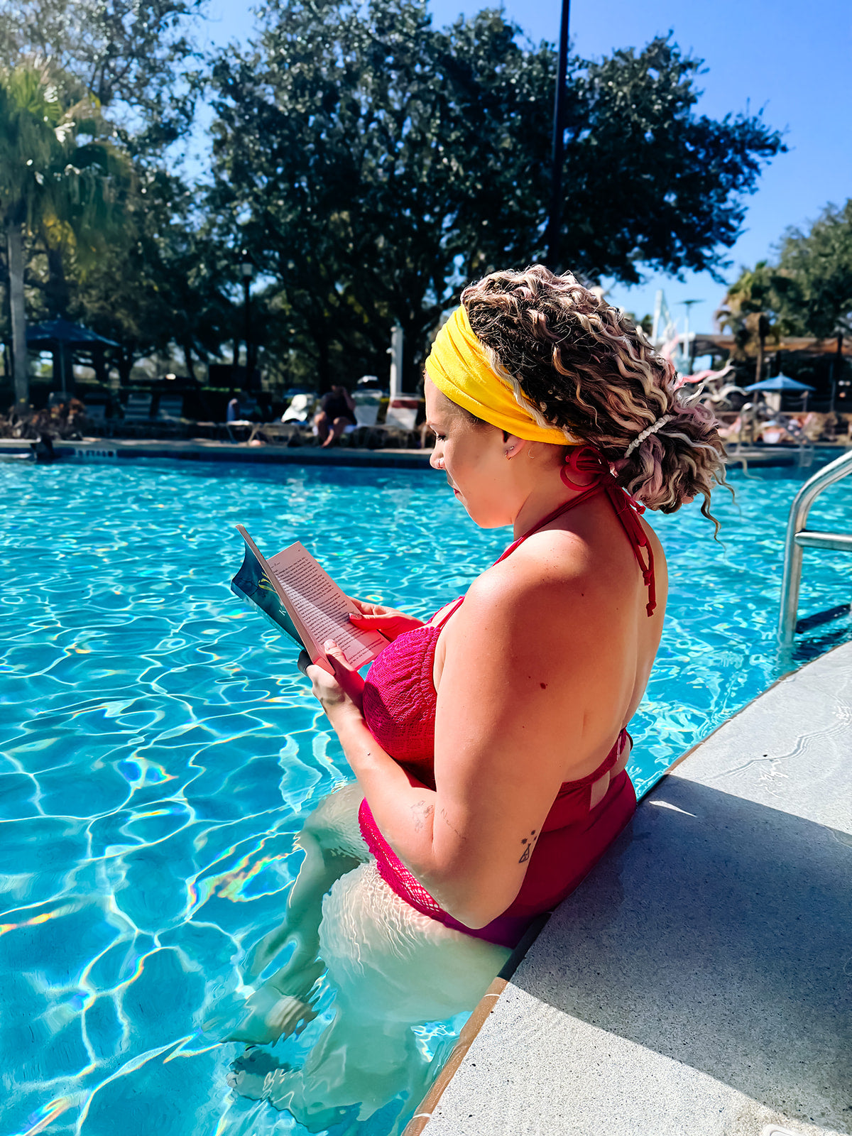 girl in pool wearing yellow ona band as a headband to hold back braid in extensions
