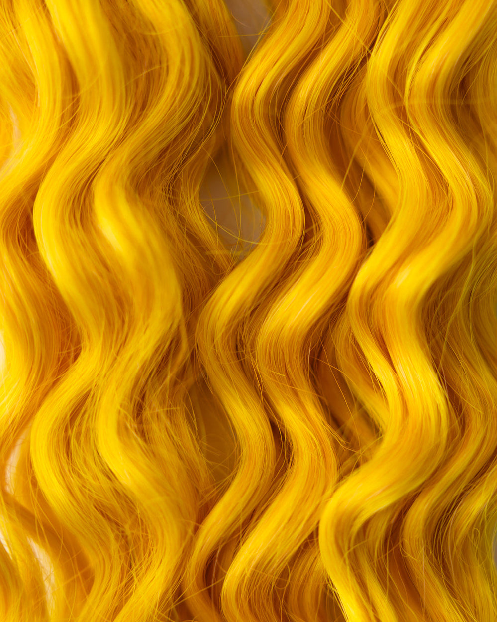 bright yellow wavy hair extensions filling the frame
