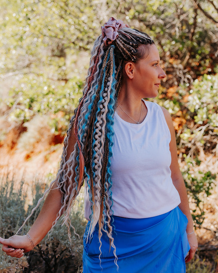 long wavy dreadlocks in blonde, brunette and blue with pink and blonde  braided accents.